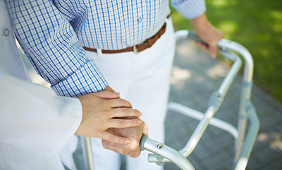 man-using-walker-with-help