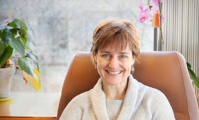 Josee Dupuis, Department Chair, Biostats; woman siting in brightly lit room wearing ivory sweater in office