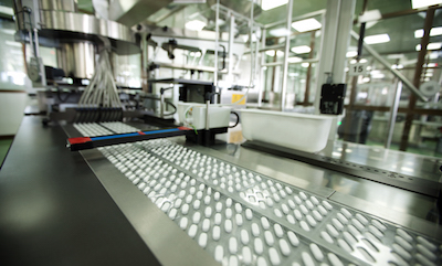 pills being packed in blisters on production line in a pharmaceutical company