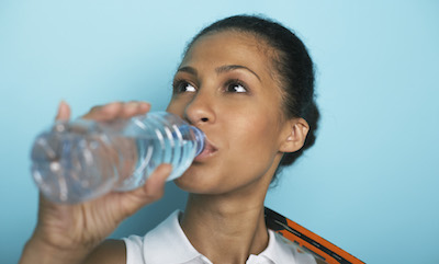 Woman drinking from plastic water bottle