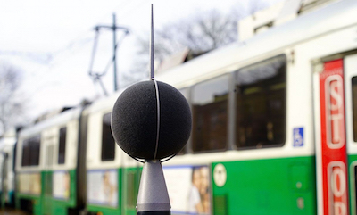 Sound monitoring equipment in front of an above-ground Green Line subway train