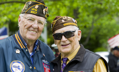 Two Massachusetts veteran of WWII and the Korean War pose together at an outdoors Memorial Day service