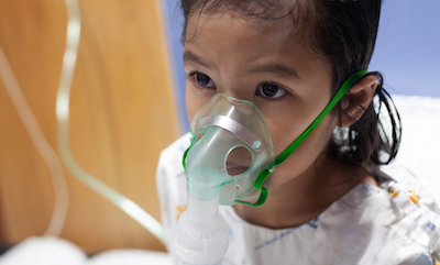 Young Thai child wearing inhaler mask