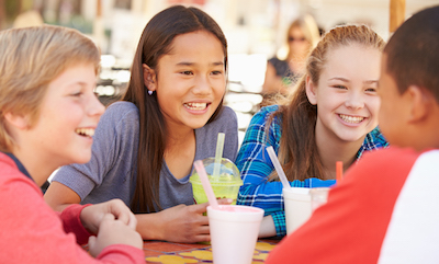 Diverse group of 10-12 year olds hanging out drinking sugary drinks