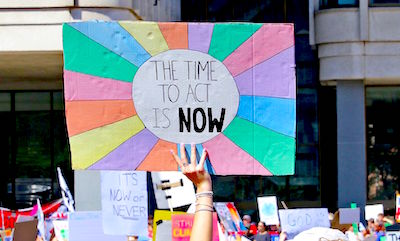 A sign at the Climate Strike in Boston reads "The Time to Act Is NOW"