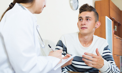 Teen boy talking with doctor