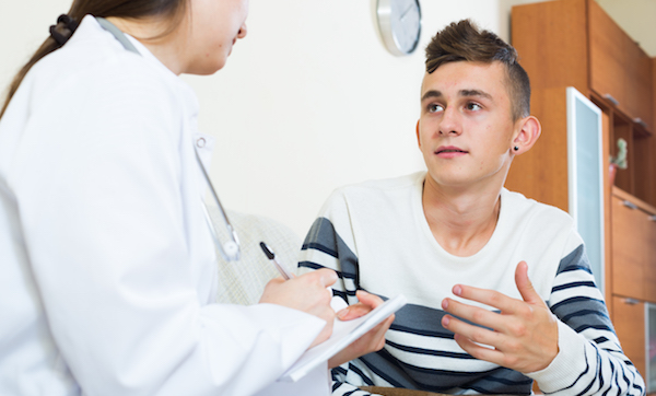 Teen boy talking with doctor