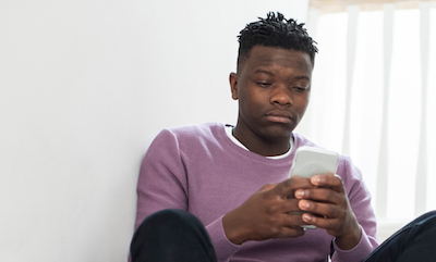 Teen boy at home looking at his phone