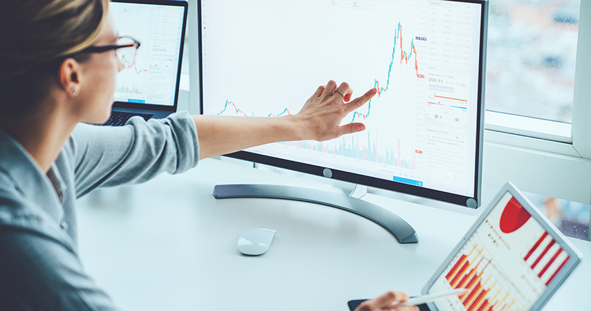 biostatistics: woman cross-referencing computer scree -data to tablet data