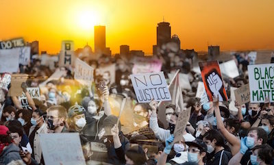 Photo of protesters in Boston by Sophie Park (CAS’20). Photo of Boston skyline at sunrise by Vernon Doucette