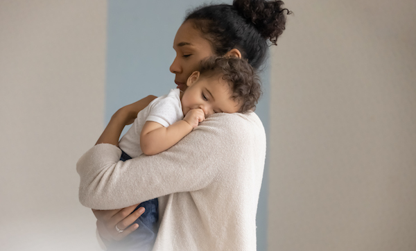 Loving biracial mom embrace little baby infant