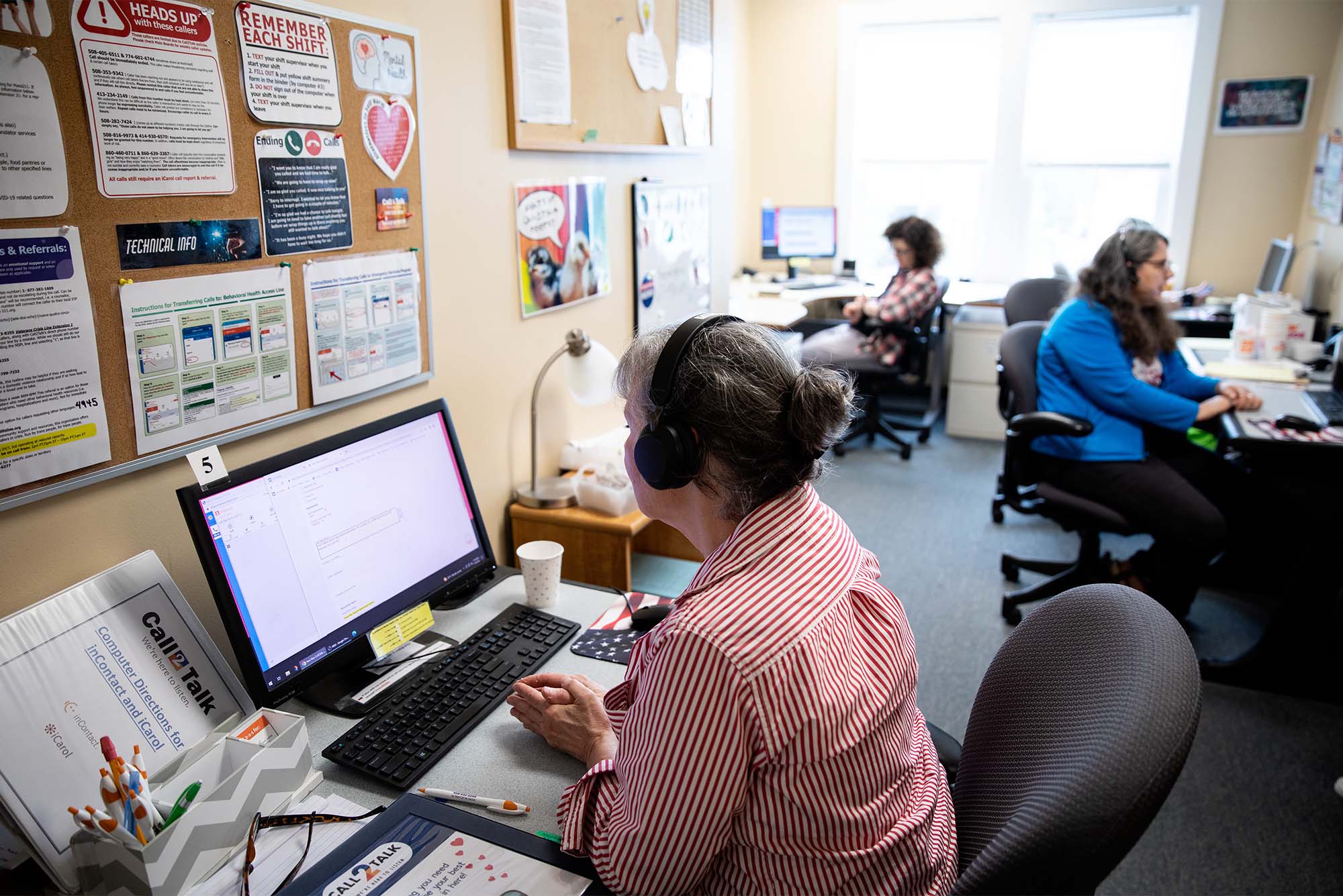 988 line operators sit at desks fielding calls