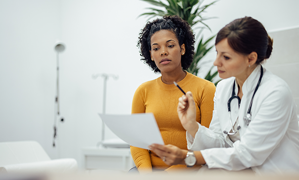 Doctor reads off a paper to woman patient