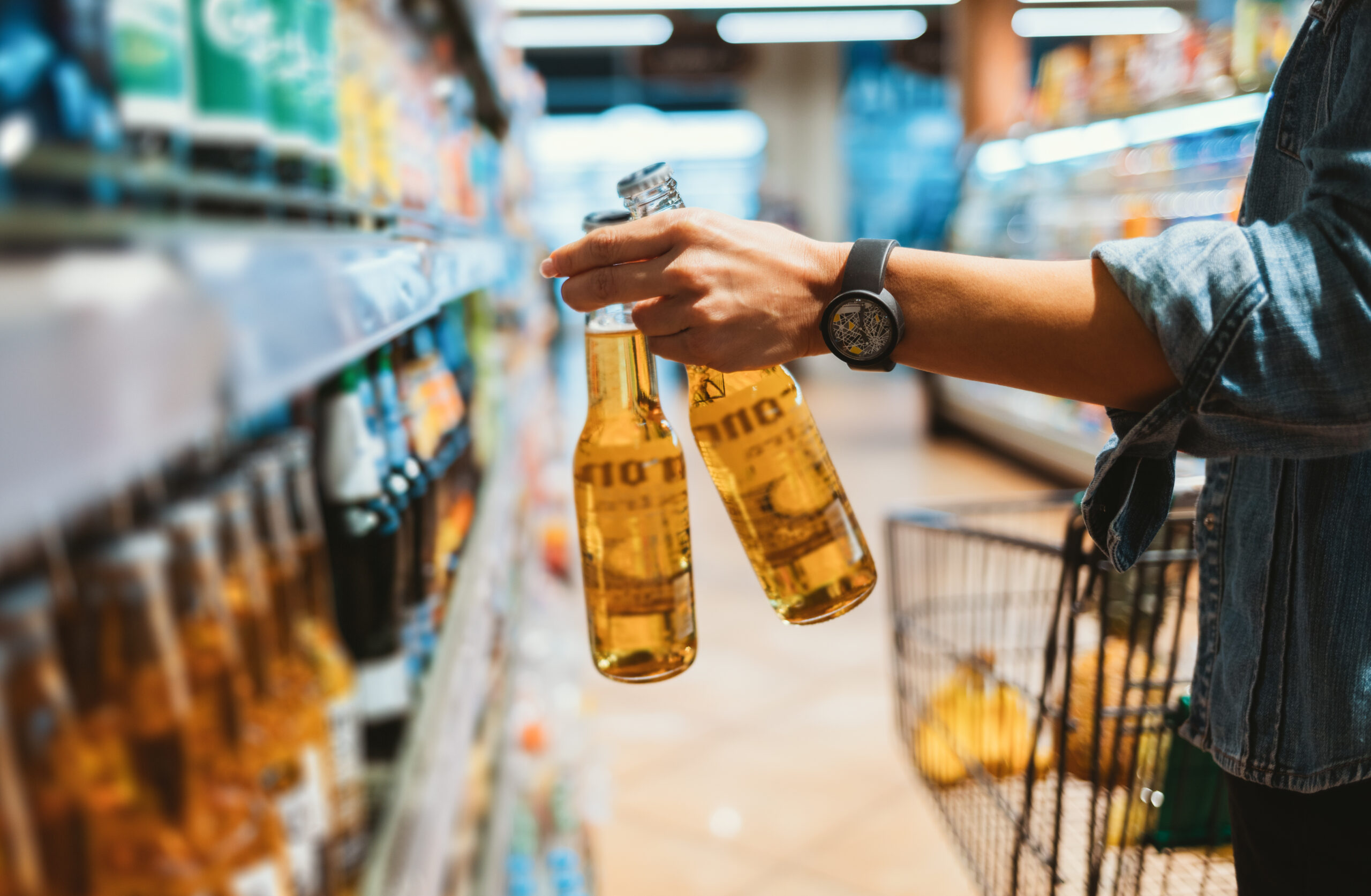 Close-up of hand holding two glass beer bottles