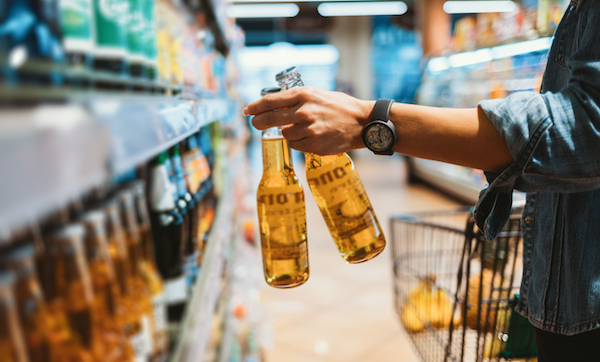 Close-up of hand holding two glass beer bottles