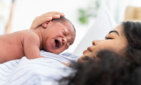 Newborn baby crying on mother's chest