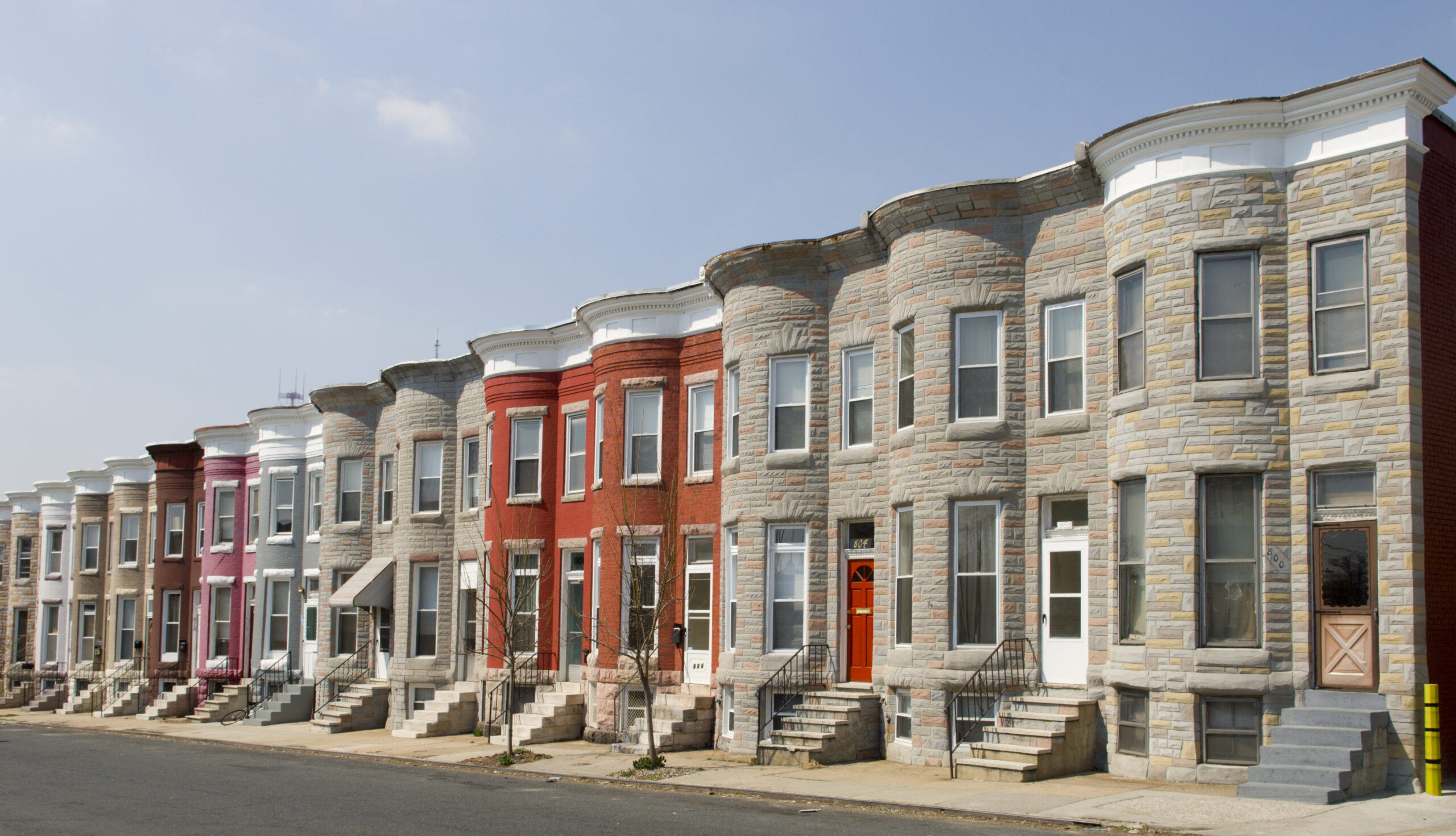 Colorful row houses along a sunny residential, quiet street.