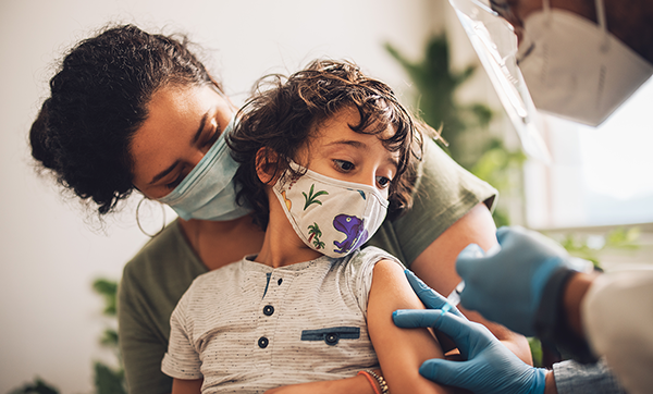 Child receives vaccination while on his mother's lap