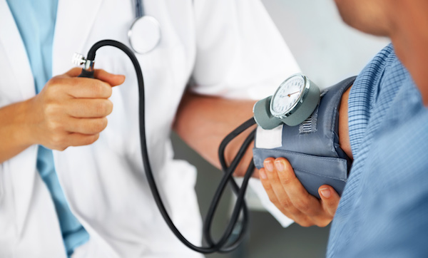 A doctor check's patient's blood pressure with arm cuff