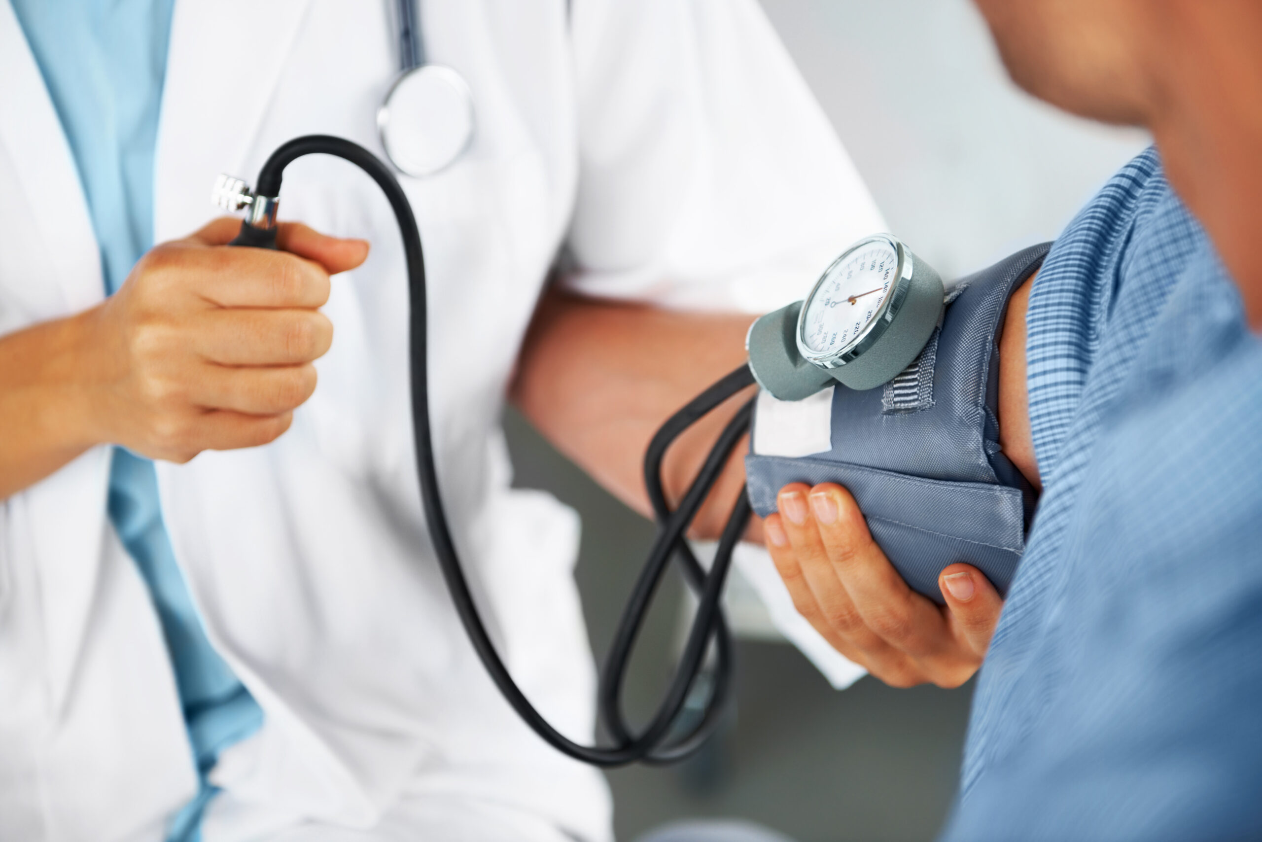 A doctor check's patient's blood pressure with arm cuff
