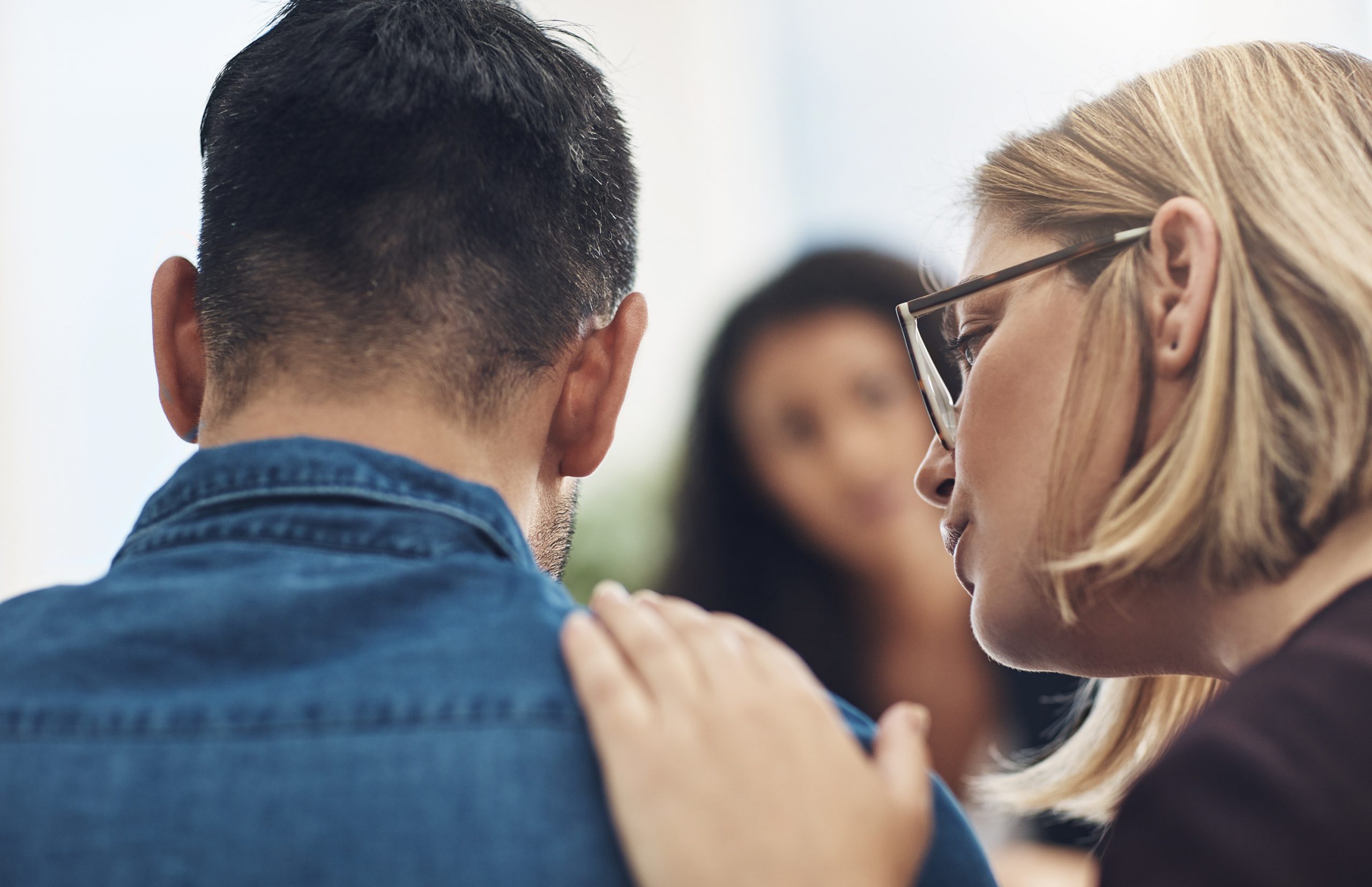 Shot of a wife consoling her husband during a counseling session with a therapist