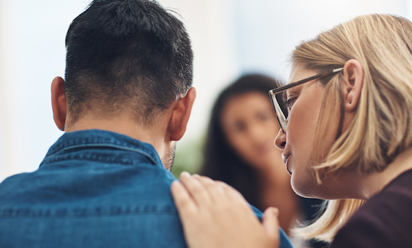 Shot of a wife consoling her husband during a counseling session with a therapist