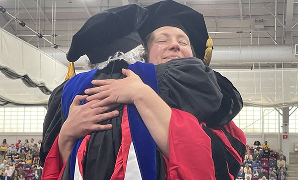 Graduate hugs faculty member at BUSPH graduation