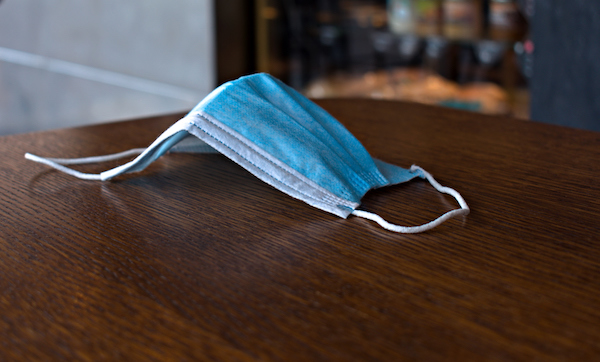 Blue medical anti virus mask close up on blurred wooden table