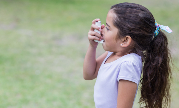 Little girl using inhaler