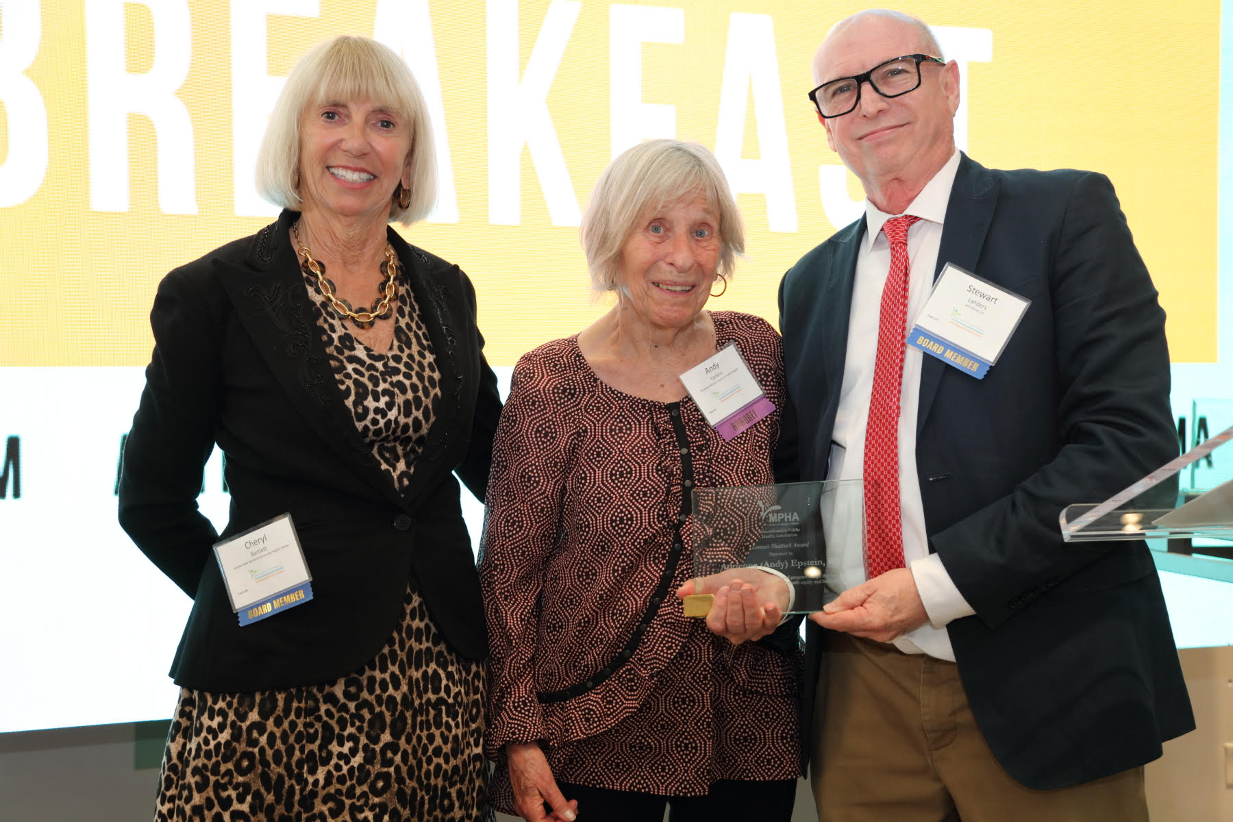 MPHA Board Members Cheryl Bartlett (left), CEO of New Bedford Community Health, and Stewart Landers (right), senior consultant at John Snow, Inc., present award to honoree Adrienne "Andy" Epstein (center).