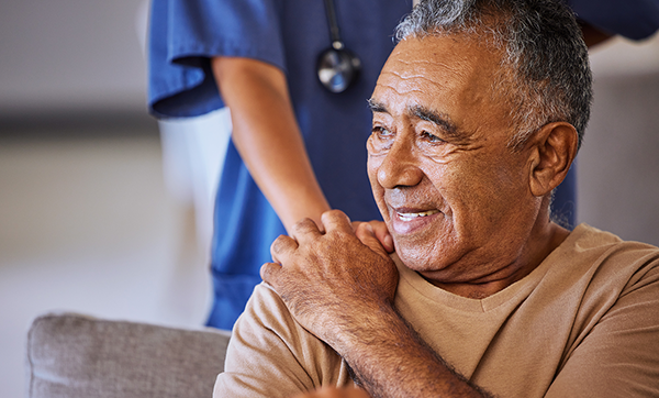 Nurse places hand on elderly man's shoulder