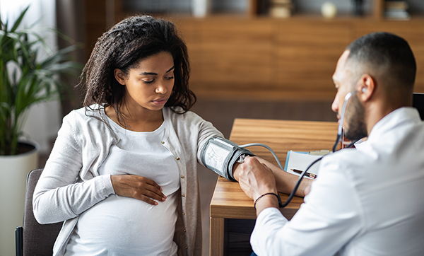 Doctor takes the blood pressure of a pregnant woman