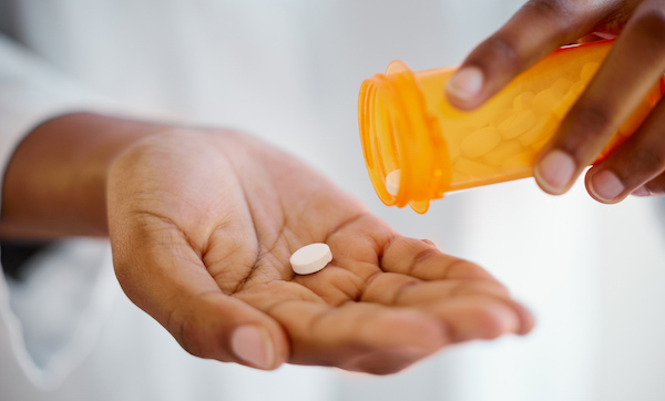 Shot of a person's hands taking tablets