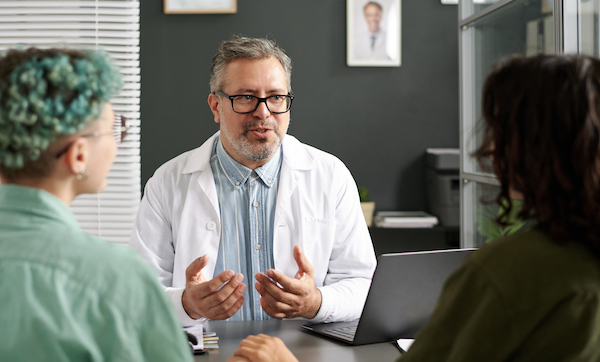 Doctor talking to lesbian couple in office