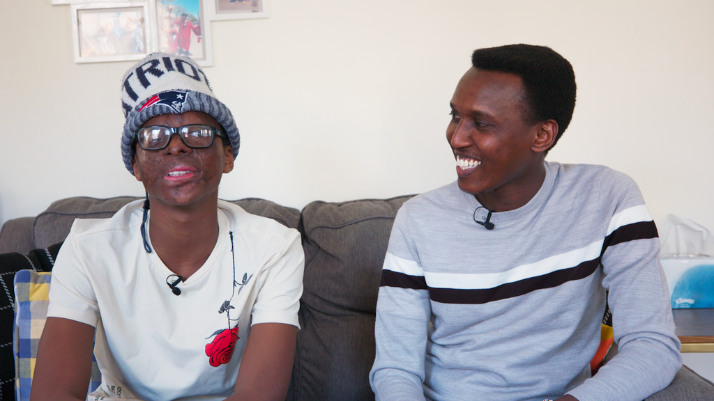 Alex Gitungao smiles at a teenage Leo who sits beside him on a couch