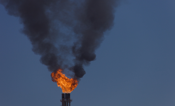 Closeup of the gas flare and dense black smoke in the sky