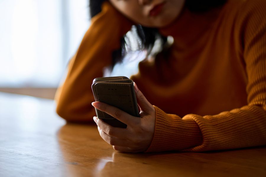 A woman who feels irritated by looking at her smartphone