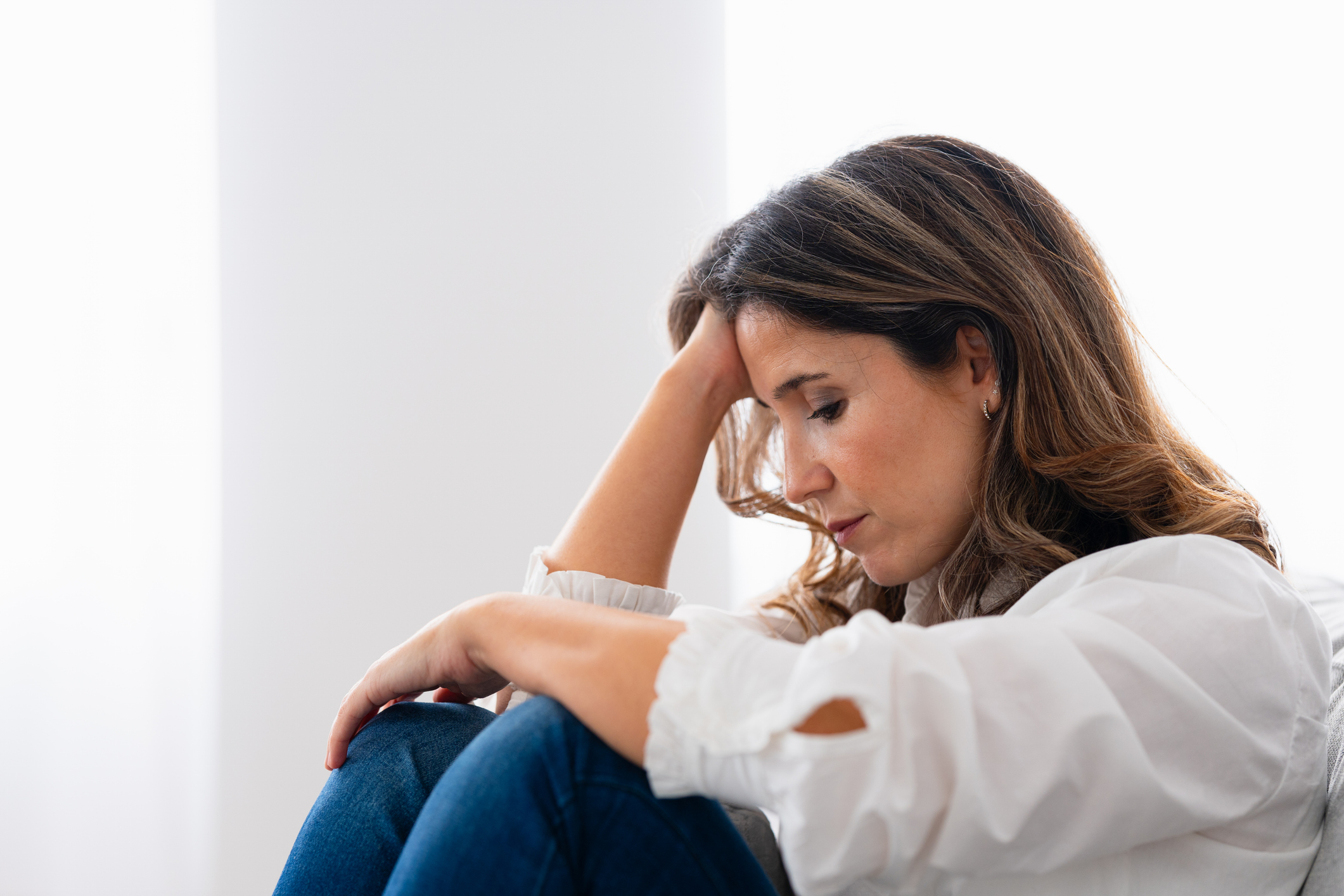 Lonely woman sitting at home with sad look