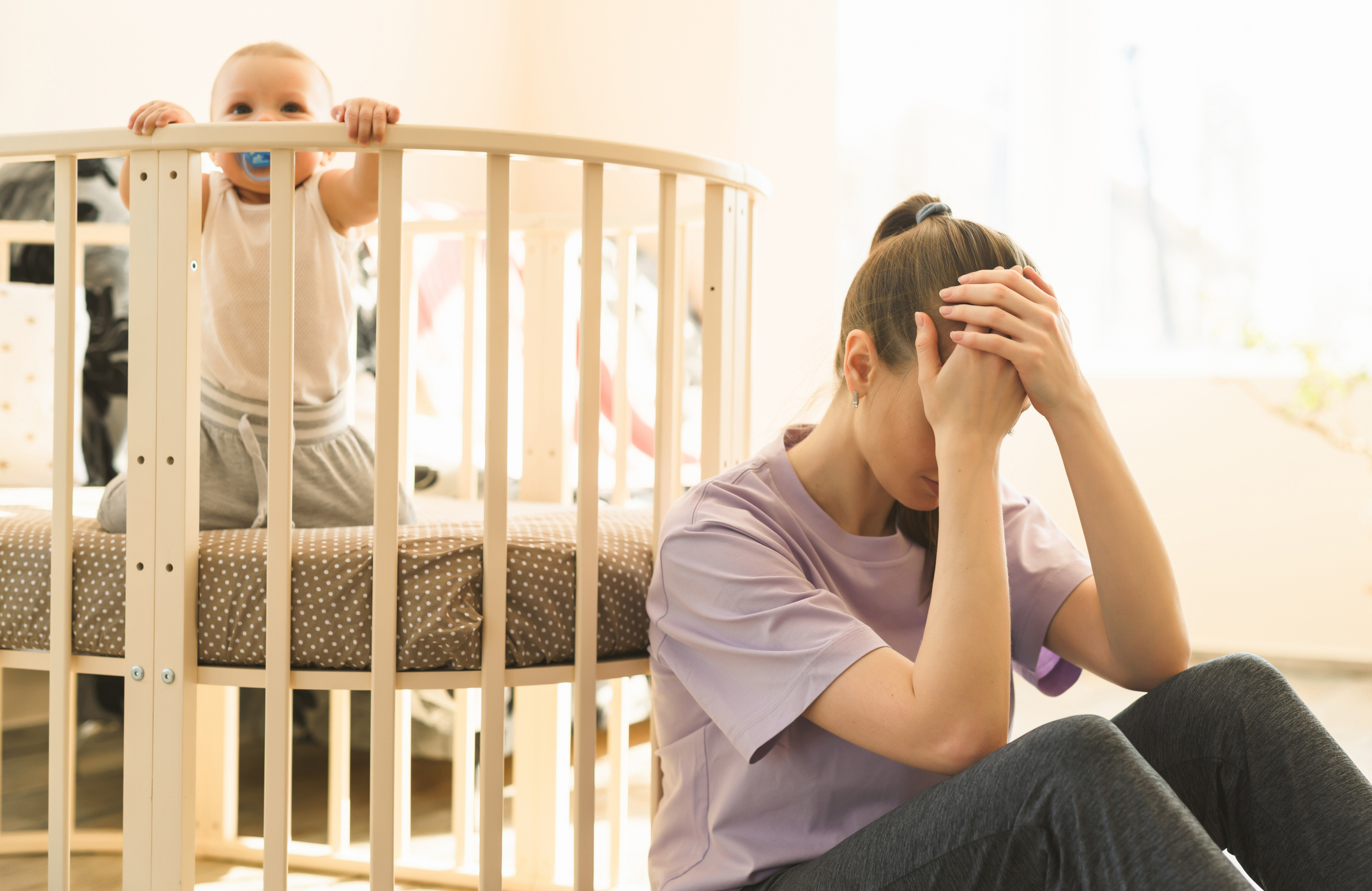 The mother is very tired, and the child does not want to fall asleep. Mom's trying to take a nap. The difficulties of motherhood, sleepless night. High quality photo