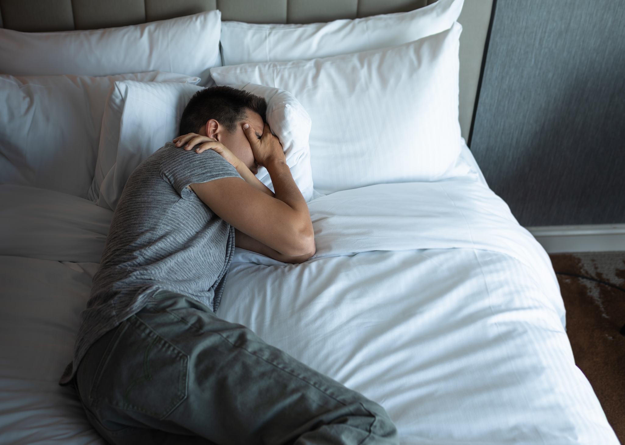 Lonely sad man lying in the bed.