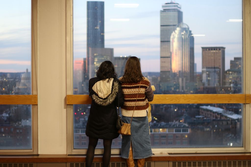 Graduates look out at the sunset from Heibert Lounge during the 2024 December Graduate Reception