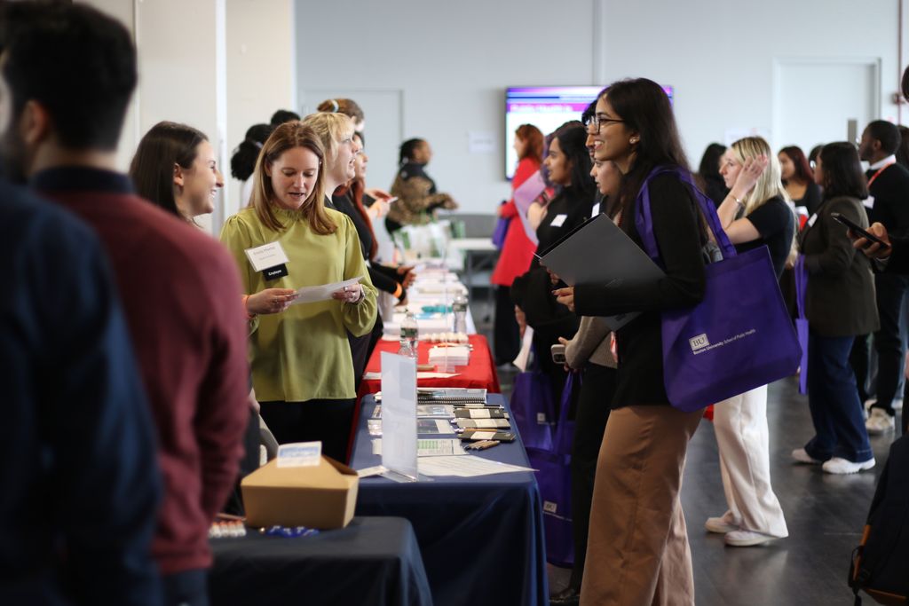A student speaks with staff members from a visiting organization during the spring 2025 career fair.