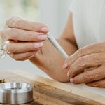 Senior woman making a weed joint at home