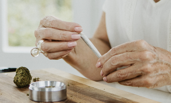 Senior woman making a weed joint at home