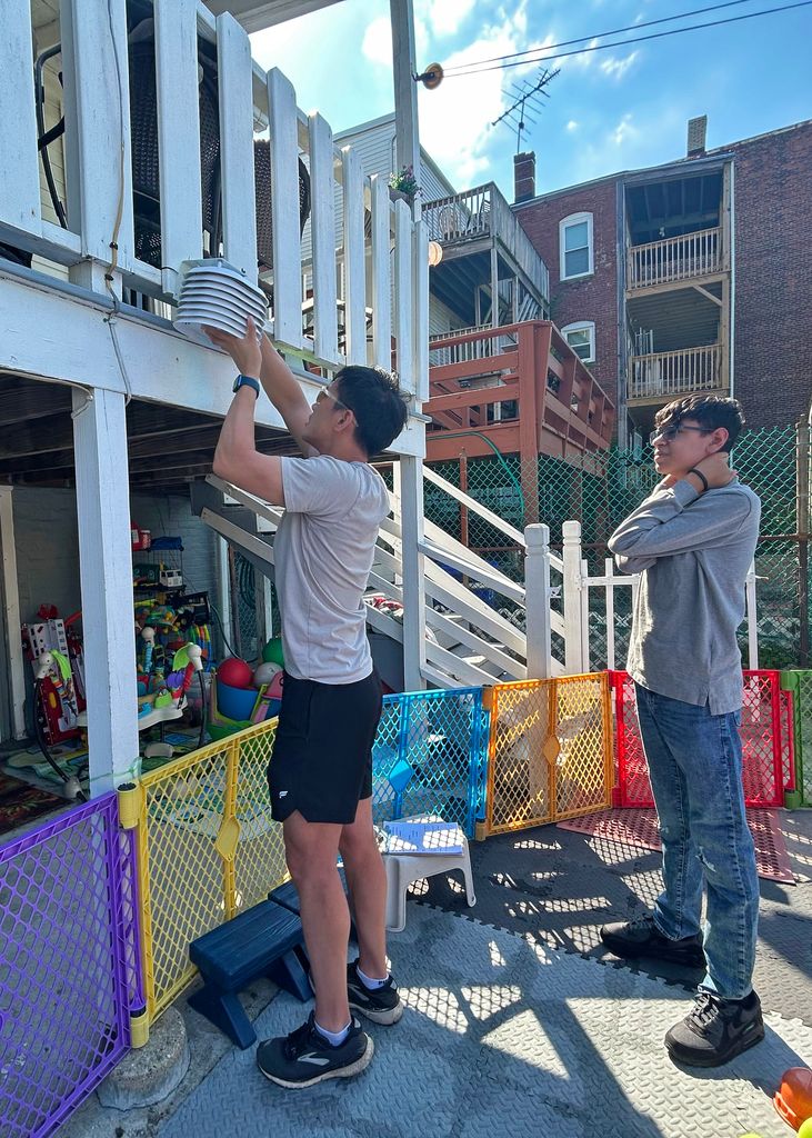 Volunteers install a temperature sensor at a childcare center.