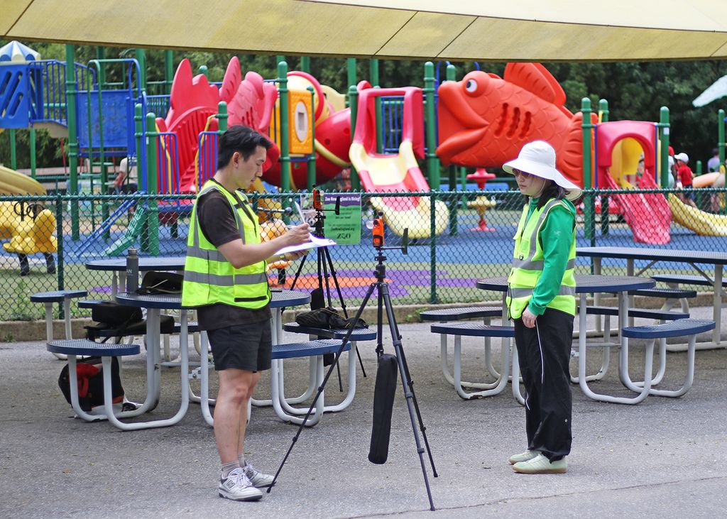Lee and Yuan record cloud cover over a sensor positioned outside a shade structure at the Franklin Park Zoo.