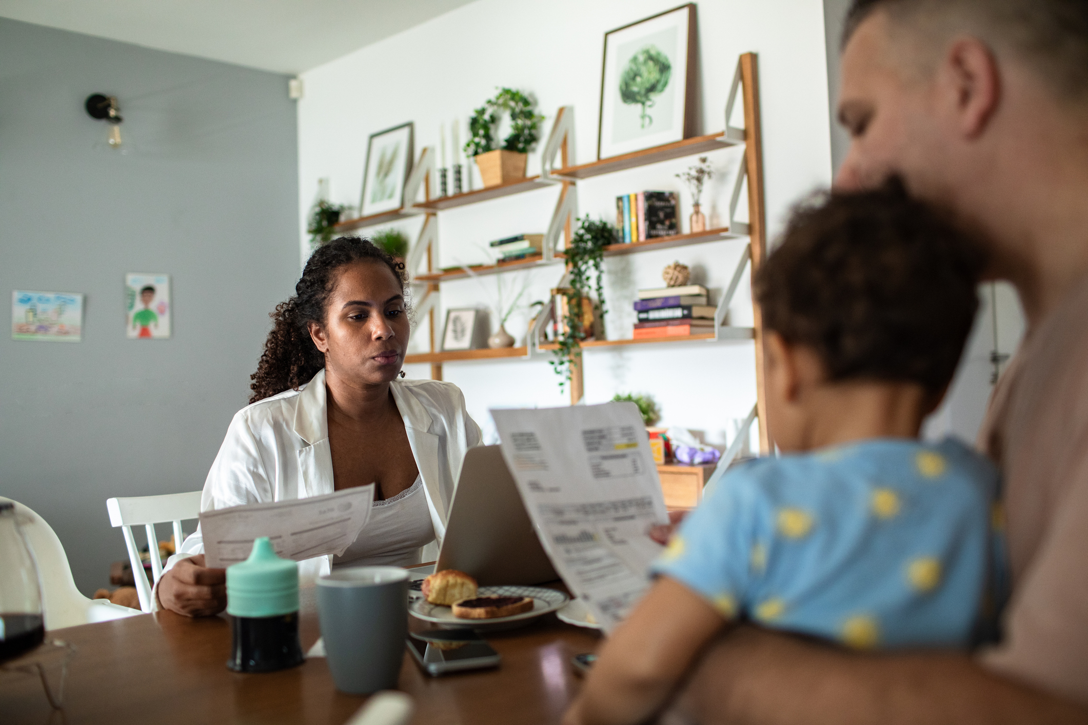 Young family having breakfast and going over their bills and home finances on the laptop
