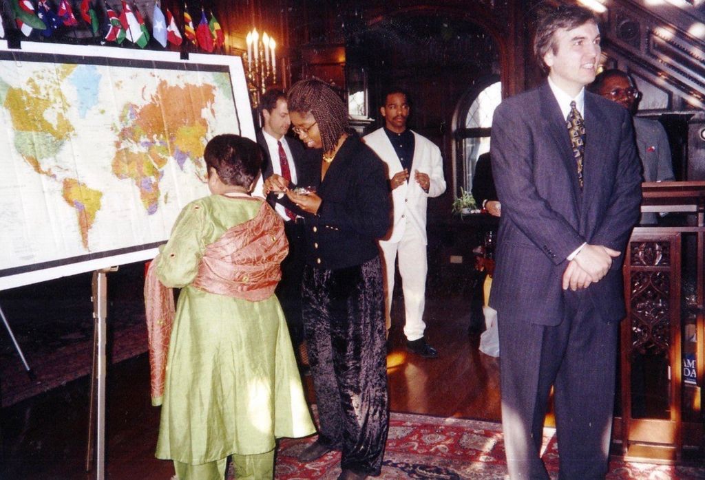 Assistant Professor Michael Trisolini addresses graduates of the Financing Healthcare in Developing Countries course. Mike Devlin and Saroj Bala Chada are seen in the background. Graduates mark their countries on a world map.
