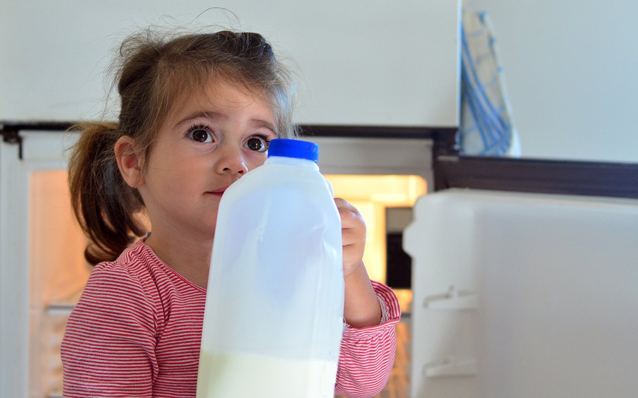 girl-holds-a-bottle-of-milk-at-home.