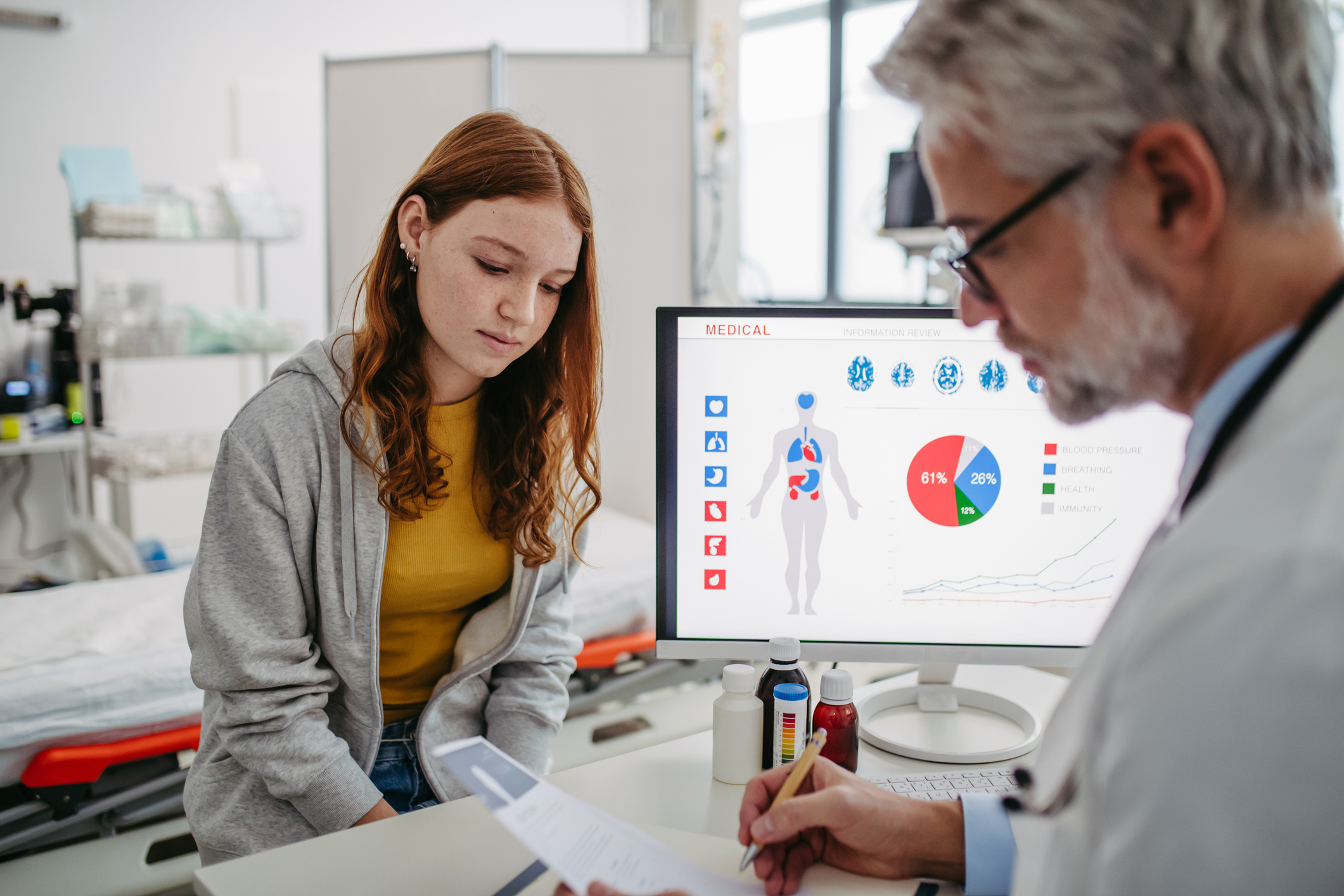 Teenage girl visiting doctor, discussing test results. Concept of preventive health care for adolescents.